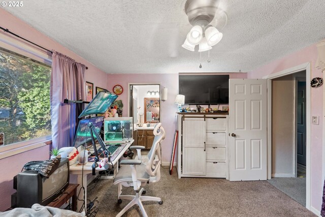 home office with ceiling fan, carpet, and a textured ceiling