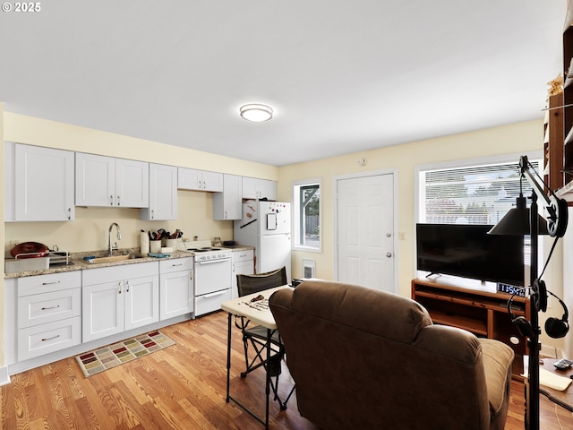 1560 S Downing St, Seaside, OR 97138 - kitchen with white appliances, a sink, light wood finished floors, and white cabinets