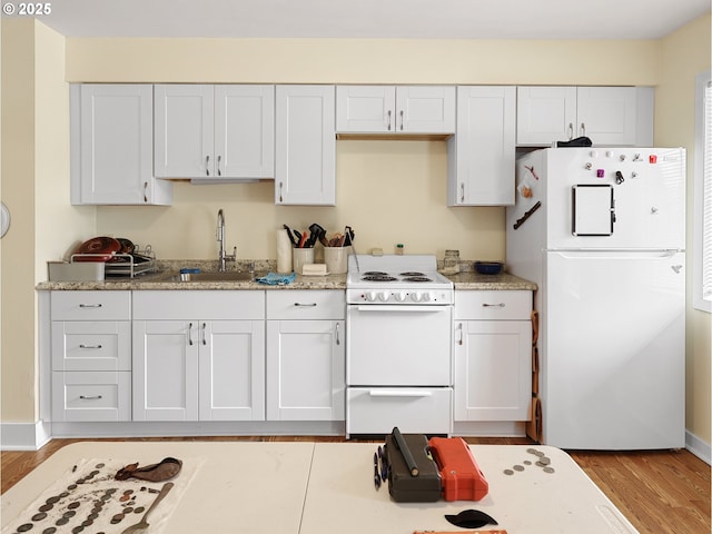 1560 S Downing St, Seaside, OR 97138 - kitchen with white appliances, a sink, wood finished floors, white cabinetry, and baseboards