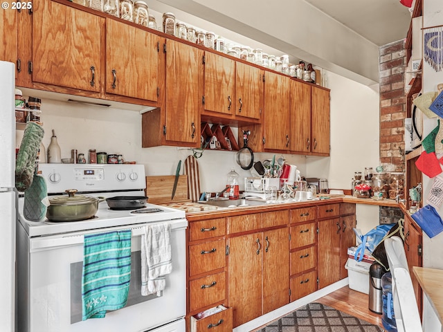 1560 S Downing St, Seaside, OR 97138 - kitchen with white range with electric stovetop, brown cabinetry, and light countertops