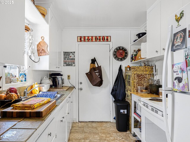 1560 S Downing St, Seaside, OR 97138 - kitchen with white appliances, light countertops, white cabinetry, a sink, and ornamental molding