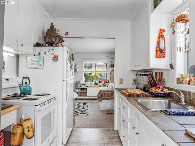 1560 S Downing St, Seaside, OR 97138 - kitchen featuring white electric range oven, a sink, white cabinetry, and ornamental molding