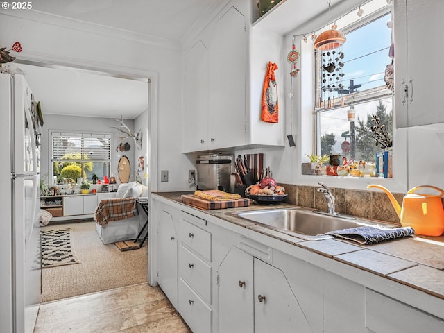 1560 S Downing St, Seaside, OR 97138 - kitchen featuring white cabinetry, a sink, freestanding refrigerator, and tile countertops
