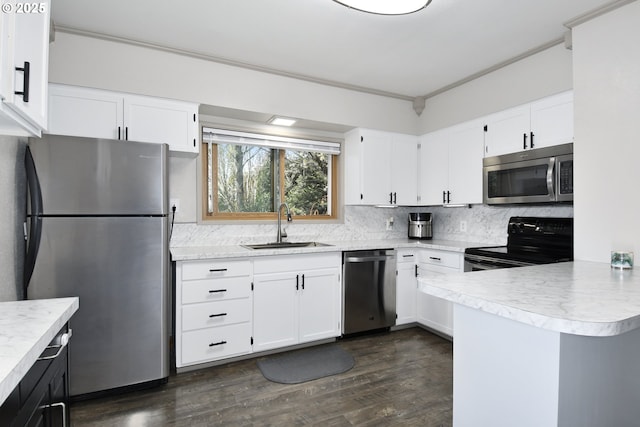 kitchen with appliances with stainless steel finishes, a sink, light countertops, decorative backsplash, and dark wood-style flooring