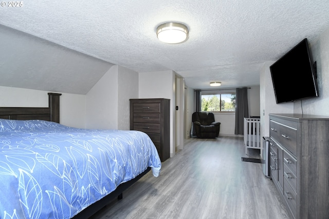 bedroom featuring light wood-type flooring and a textured ceiling
