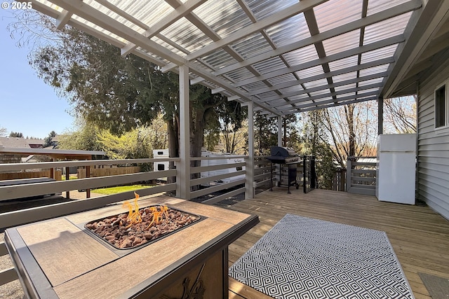 deck with a fire pit, a grill, and a pergola