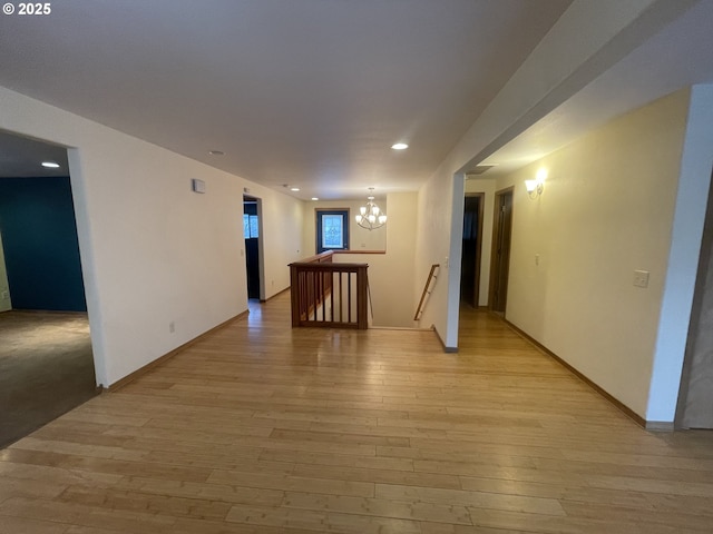 spare room with a chandelier and light hardwood / wood-style flooring