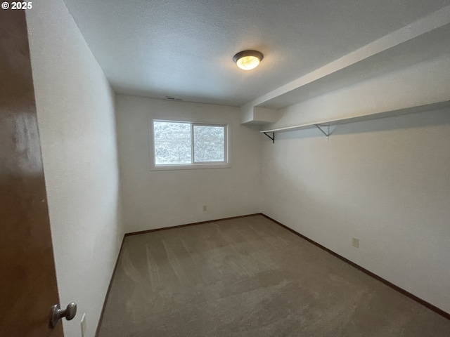 carpeted empty room featuring a textured ceiling