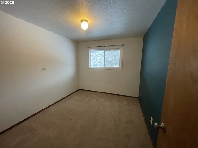 unfurnished room featuring carpet flooring and a textured ceiling