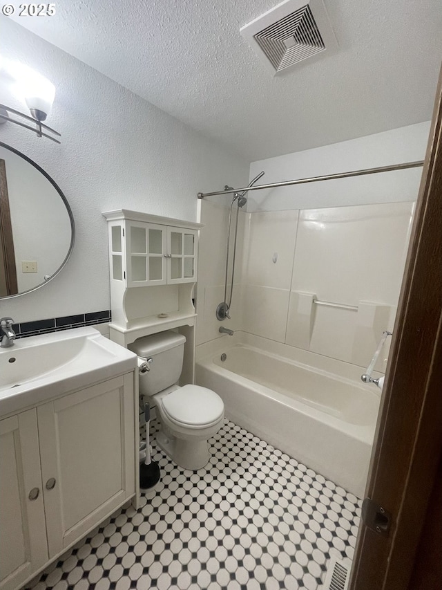 full bathroom featuring shower / tub combination, vanity, toilet, and a textured ceiling