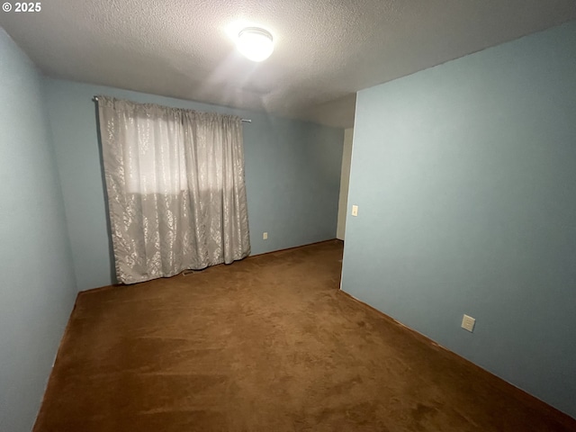 carpeted empty room featuring a textured ceiling