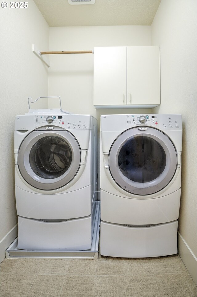 619 SW Foresta Ter, Portland, OR 97225 - laundry room featuring washer and clothes dryer, cabinet space, and baseboards