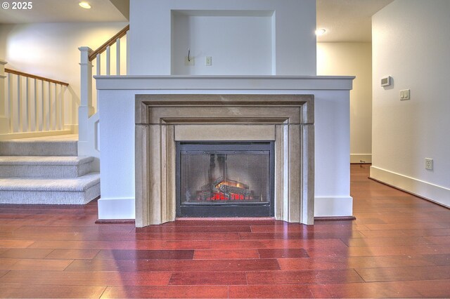 619 SW Foresta Ter, Portland, OR 97225 - detailed view of a glass covered fireplace, wood finished floors, recessed lighting, and baseboards