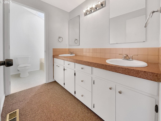 full bath featuring toilet, backsplash, a sink, and visible vents