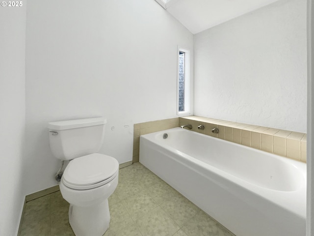 full bathroom with baseboards, toilet, tile patterned floors, vaulted ceiling, and a bath