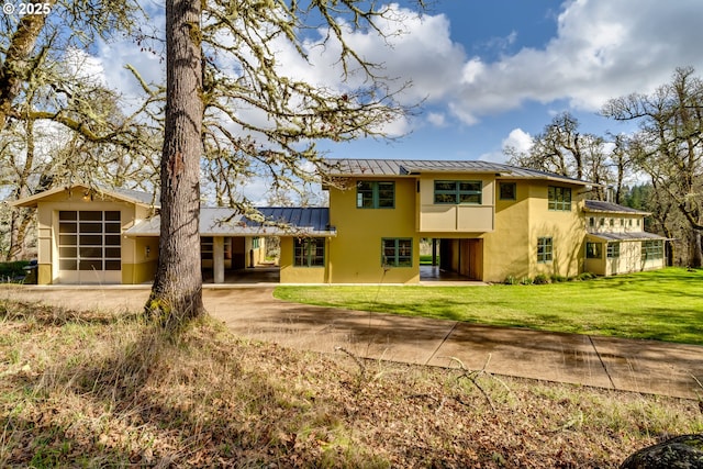 85789 Allbritain Ln, Eugene, OR 97405 - rear view of house with a standing seam roof, a metal roof, stucco siding, and a yard