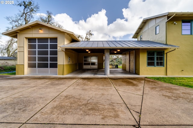 85789 Allbritain Ln, Eugene, OR 97405 - view of front of house featuring stucco siding, driveway, a carport, and a metal roof