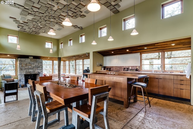 85789 Allbritain Ln, Eugene, OR 97405 - dining area featuring a towering ceiling, a stone fireplace, and healthy amount of natural light