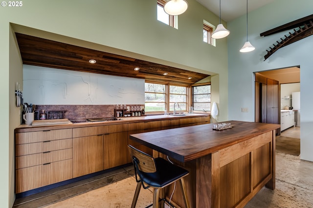 85789 Allbritain Ln, Eugene, OR 97405 - kitchen featuring butcher block countertops, a towering ceiling, cooktop, healthy amount of natural light, and decorative light fixtures