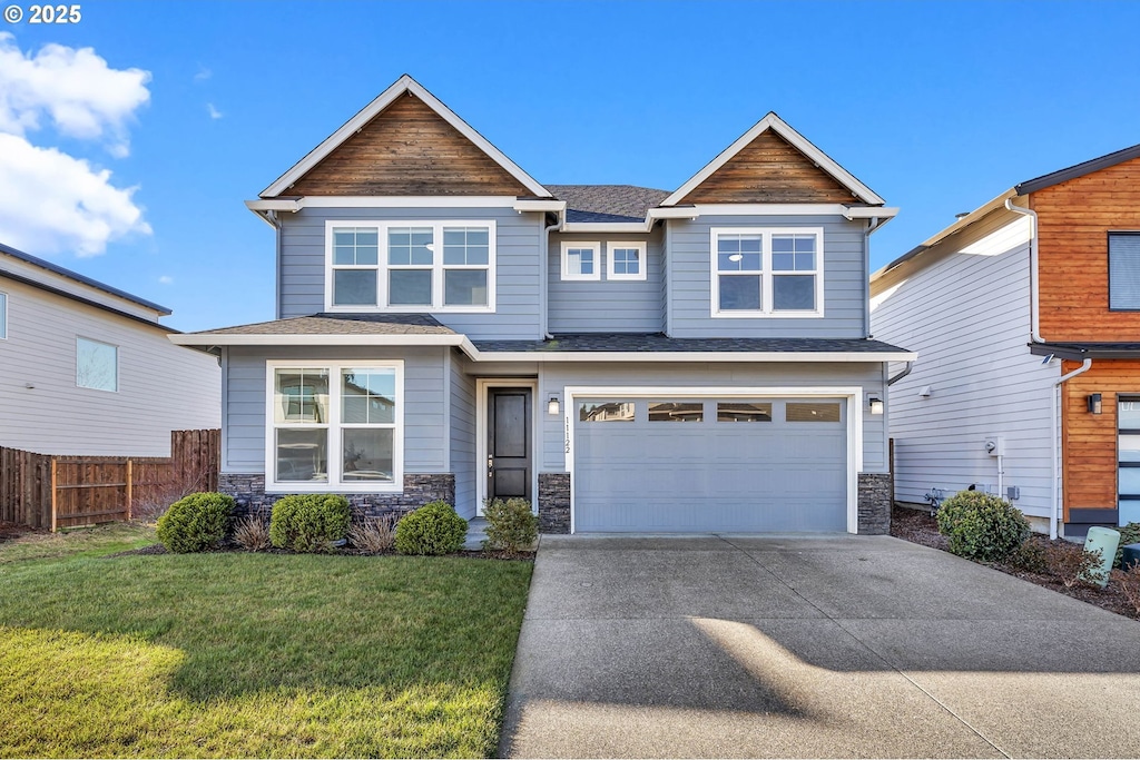 craftsman-style house featuring a garage and a front yard