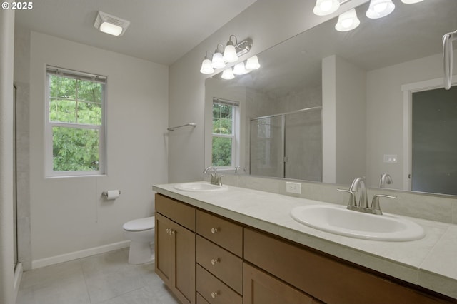 bathroom featuring a shower stall, tile patterned floors, toilet, double vanity, and baseboards