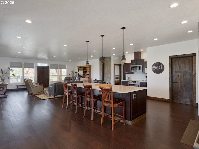 128 Kennedy Rd, Onalaska, WA 98570 - kitchen featuring stainless steel appliances, a large island, dark wood finished floors, light countertops, and recessed lighting