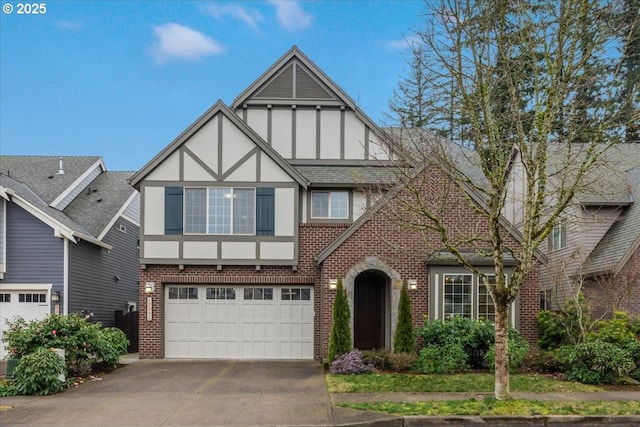 english style home featuring driveway, brick siding, a garage, and stucco siding