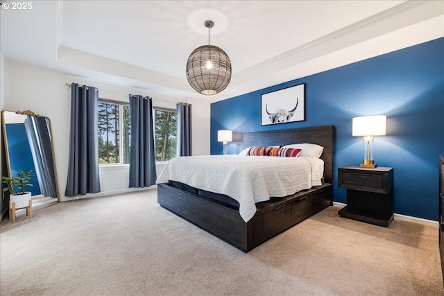 carpeted bedroom with baseboards and a raised ceiling