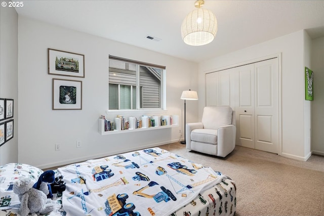 carpeted bedroom with visible vents, baseboards, and a closet