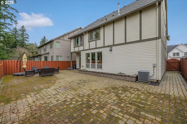 rear view of house with cooling unit, a patio area, an outdoor living space, and a fenced backyard