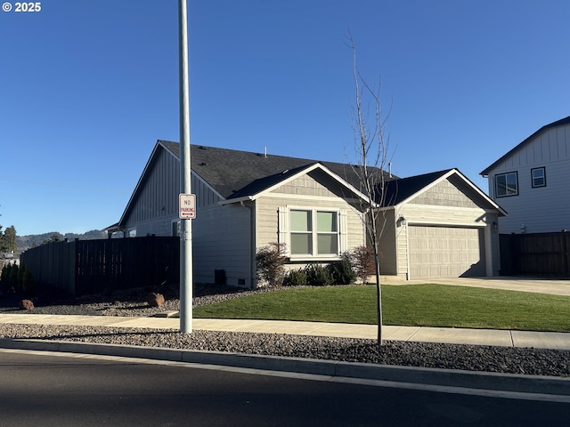 view of front of home featuring fence, a front lawn, concrete driveway, a garage, and board and batten siding