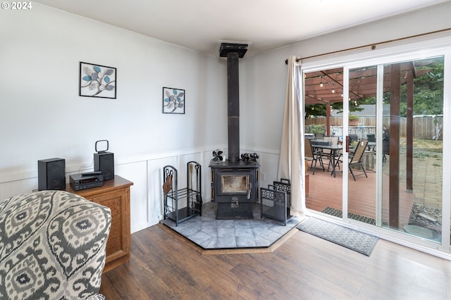 living room with dark wood-type flooring and a wood stove