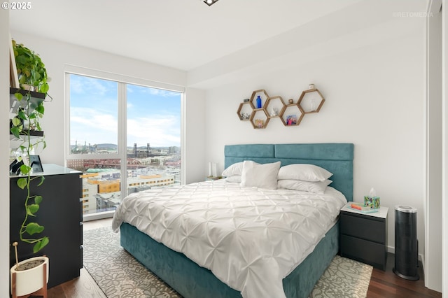 bedroom with a city view and wood finished floors