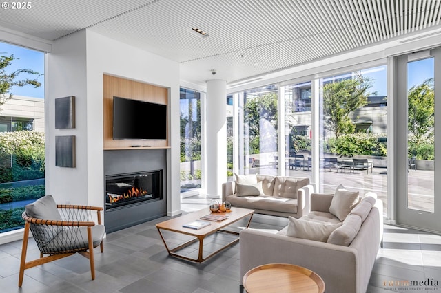 sunroom with a glass covered fireplace and a wealth of natural light