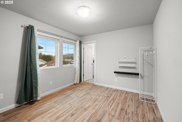 spare room featuring light wood-type flooring and a textured ceiling