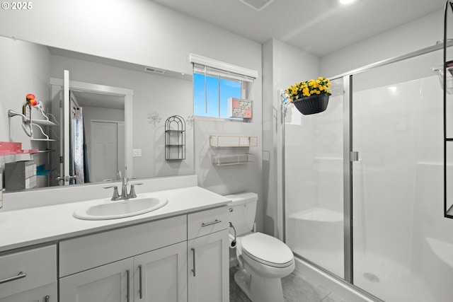 bathroom with tile patterned floors, vanity, toilet, and an enclosed shower