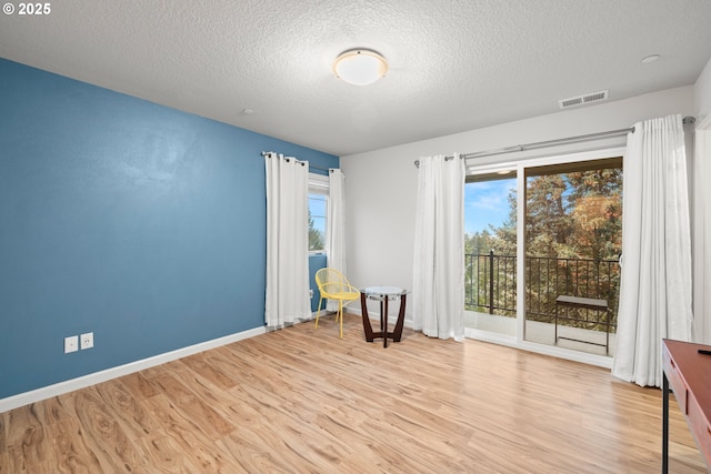 unfurnished room featuring a textured ceiling and light wood-type flooring