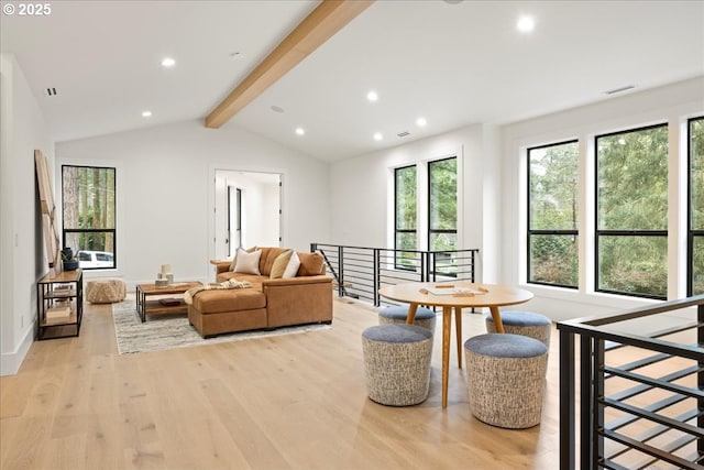 living room with light wood-type flooring and vaulted ceiling with beams