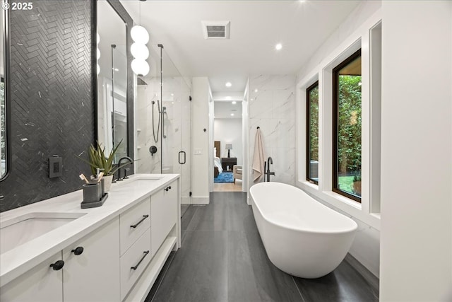 bathroom with plus walk in shower, tile walls, and vanity