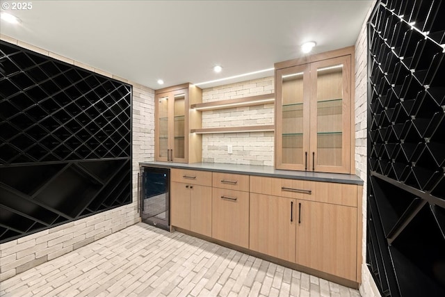 bar with light brown cabinets and wine cooler