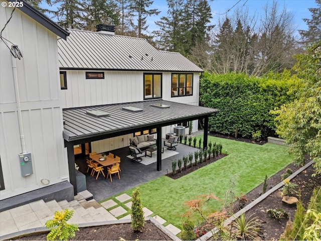 back of house with outdoor lounge area, central AC unit, a lawn, and a patio