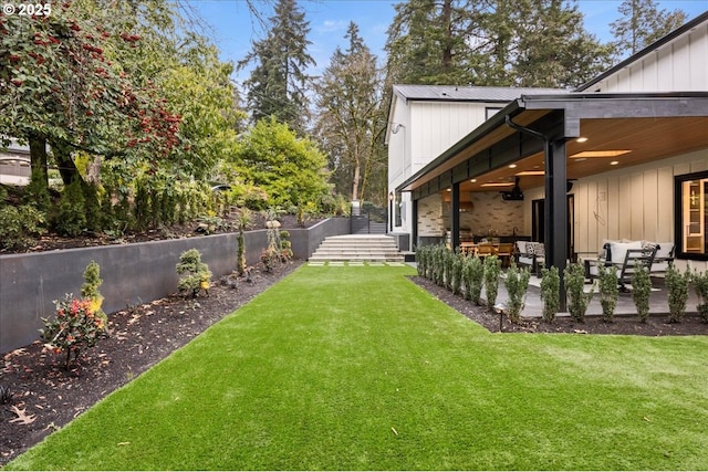 view of yard with ceiling fan and a patio