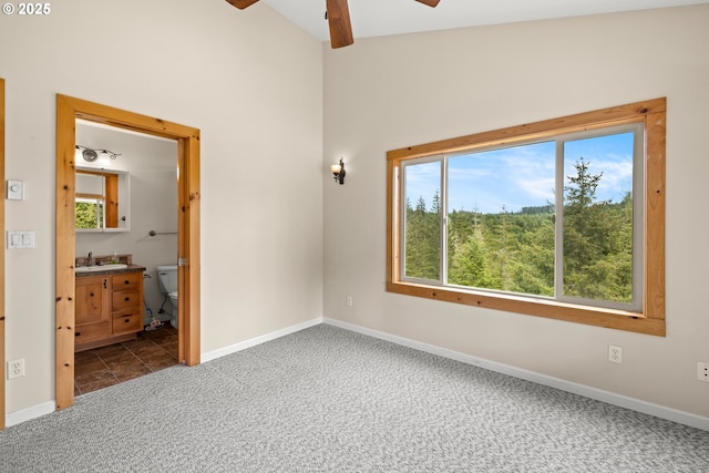 unfurnished bedroom with carpet, baseboards, high vaulted ceiling, ensuite bath, and a sink