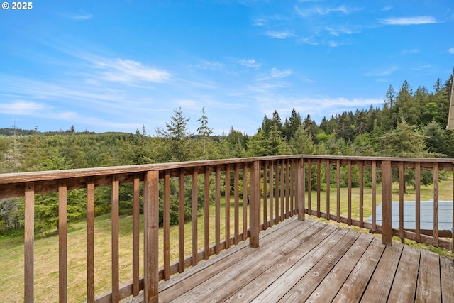 deck featuring a yard and a view of trees