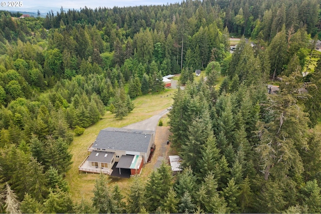 aerial view of property and surrounding area with a heavily wooded area