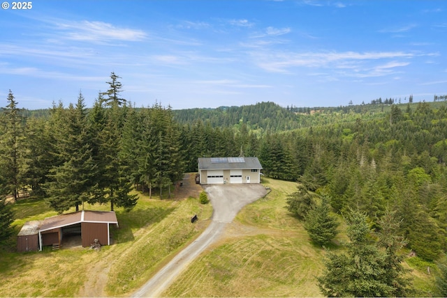 aerial view of property and surrounding area with a forest