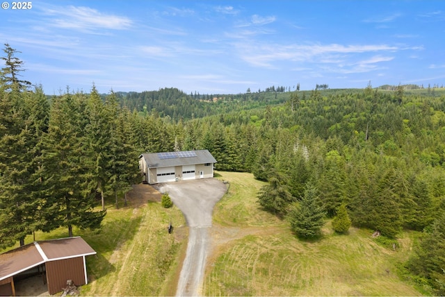 view from above of property with a heavily wooded area