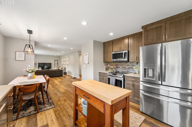 15915 SE Harold Ave, Milwaukie, OR 97267 - kitchen with stainless steel appliances, wooden counters, tasteful backsplash, wood finished floors, and recessed lighting