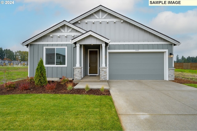 craftsman house featuring board and batten siding, a garage, driveway, and a front lawn