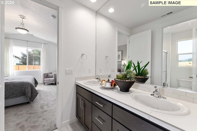 bathroom with connected bathroom, vaulted ceiling, double vanity, baseboards, and recessed lighting